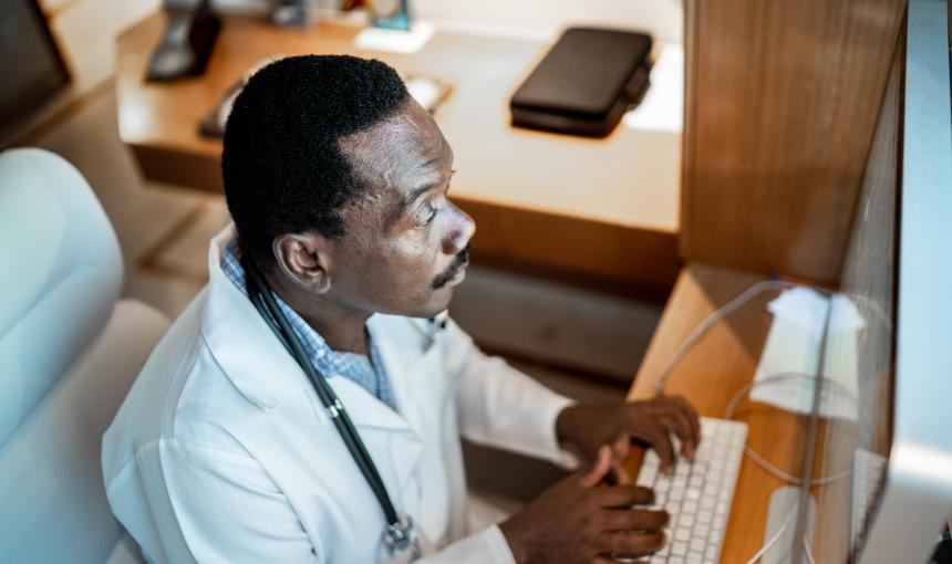 Focused doctor working using computer at the hospital